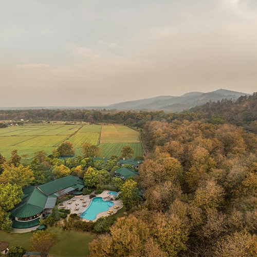 Drone shot of aahana resort with forest and mountains