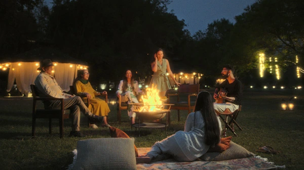Guests around a bonfire at a lawn in Aahana resort
